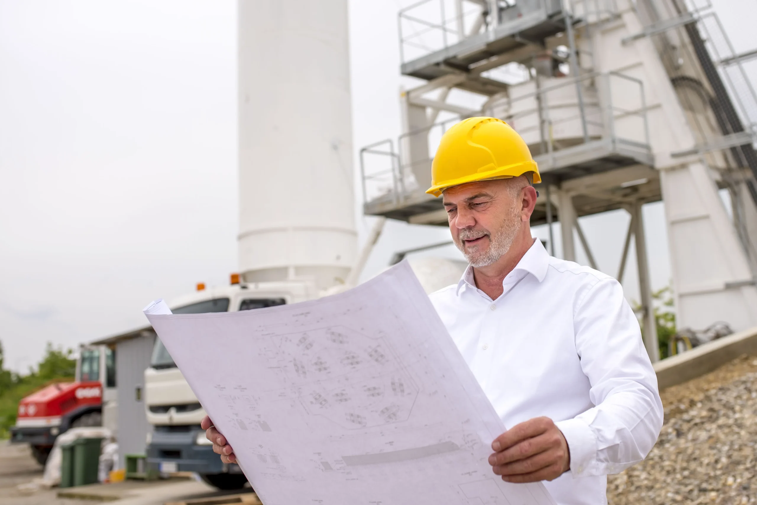 Construction manager reviewing project plans on site, showcasing effective construction management.